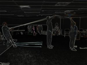A black image with neon outline of people, furniture and room interiors